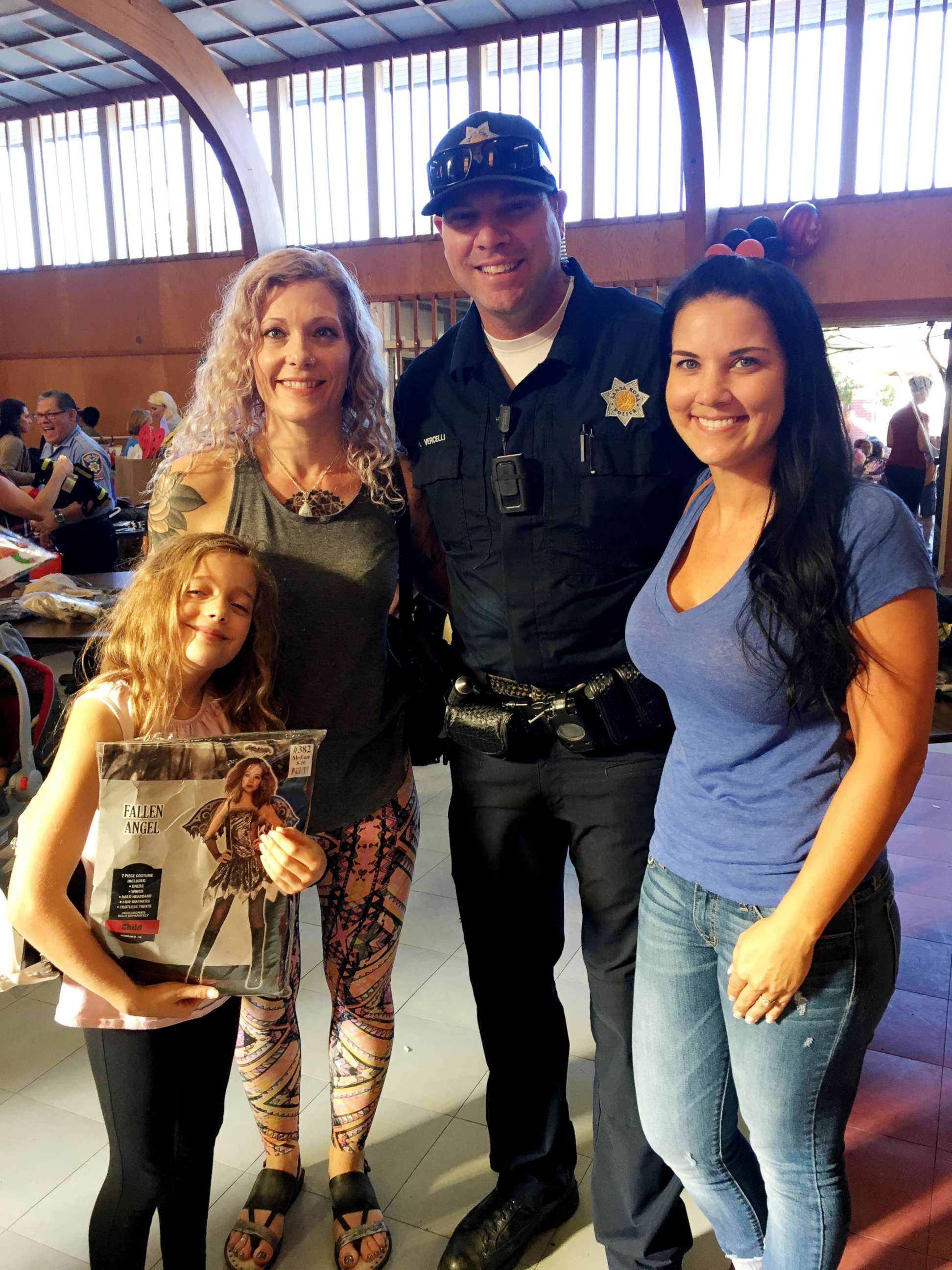PHOTO: Sascha Humphrey, 9, holds her Halloween costume as she poses with her mother, Colleen Teitgen, left, Santa Rosa Polcie Officer Nick Vercelli and his fiance.
