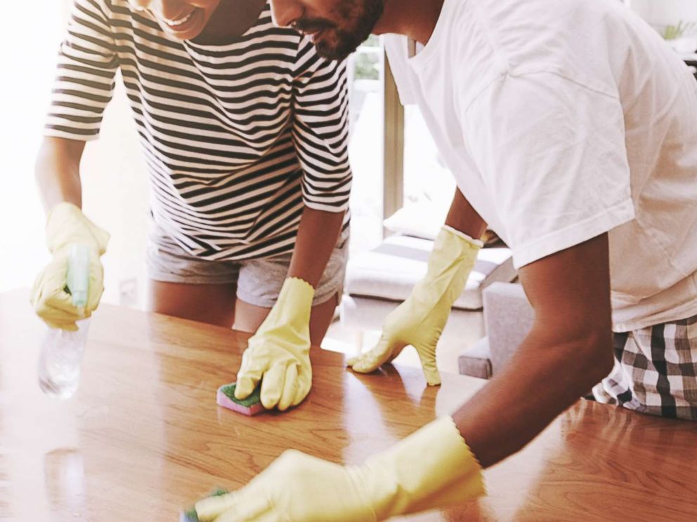 PHOTO: A young couple clean the surface of a table in an undated stock photo.