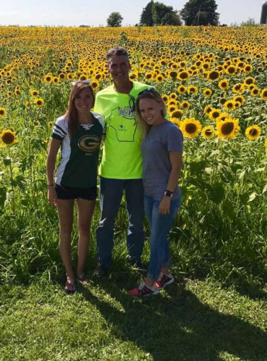PHOTO: Matt Fauske poses in front of his sunflower maze with his two other daughters, Katie and Brittany Fauske.