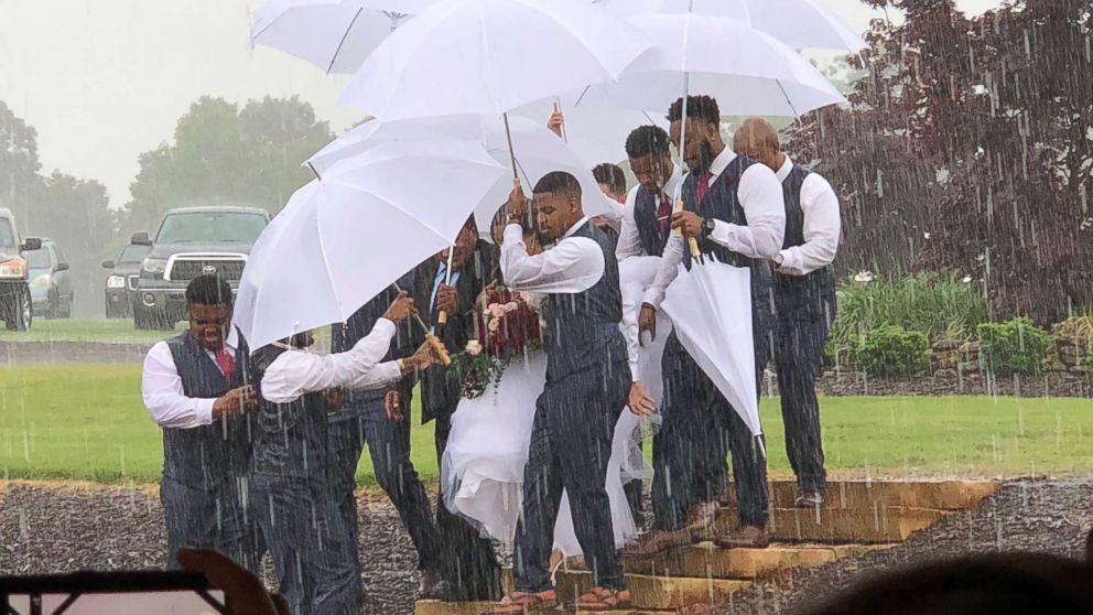 PHOTO: Diana Joseph was protected from rain on her wedding day, May 20, 2018, thanks to her husband Marcus' groomsmen.