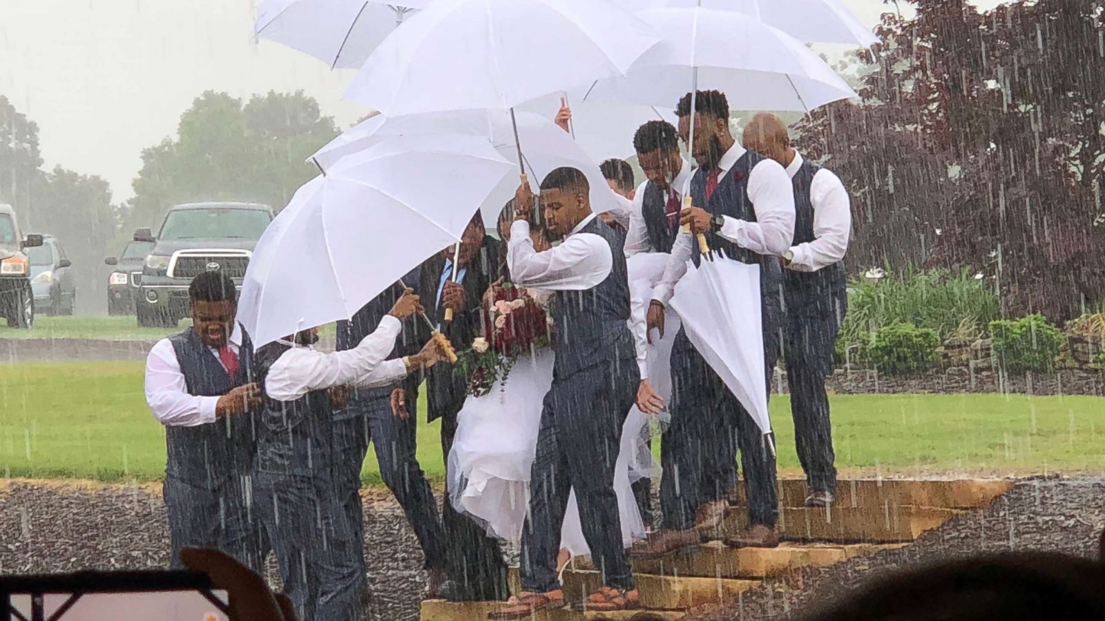 PHOTO: Diana Joseph was protected from rain on her wedding day, May 20, 2018, thanks to her husband Marcus' groomsmen.