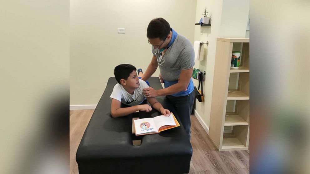 PHOTO: Yanni Rackos, 9, a patient of Roots Family Chiropractic in Chicago, Illinois, is examined by Dr. Tom Williams on July 12.