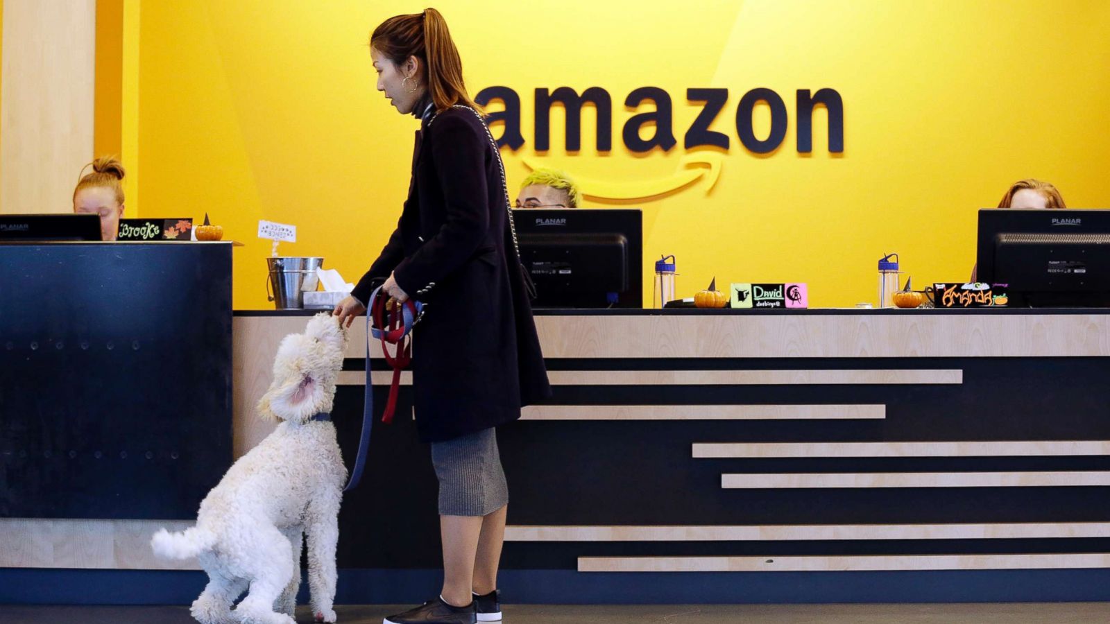 PHOTO: An Amazon employee gives her dog a biscuit as the pair head into a company building, where dogs are welcome, in Seattle, Oct. 11, 2017.