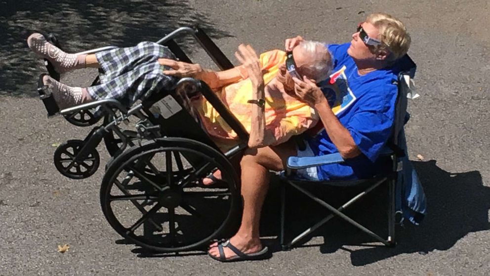 PHOTO: Hedy Morrison of Nashville, Tenn., helped her elderly father witness the total solar eclipse while tilting his wheelchair back. 