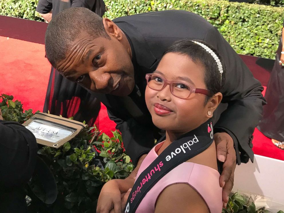 PHOTO: Francine Gascon, 10, poses with Denzel Washington as she takes photos of stars on the Golden Globes red carpet.