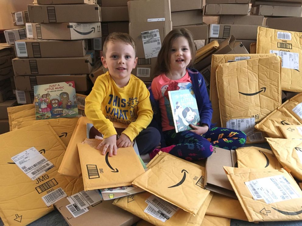 PHOTO: Lena and her twin brother Clark opening packages filled with books.