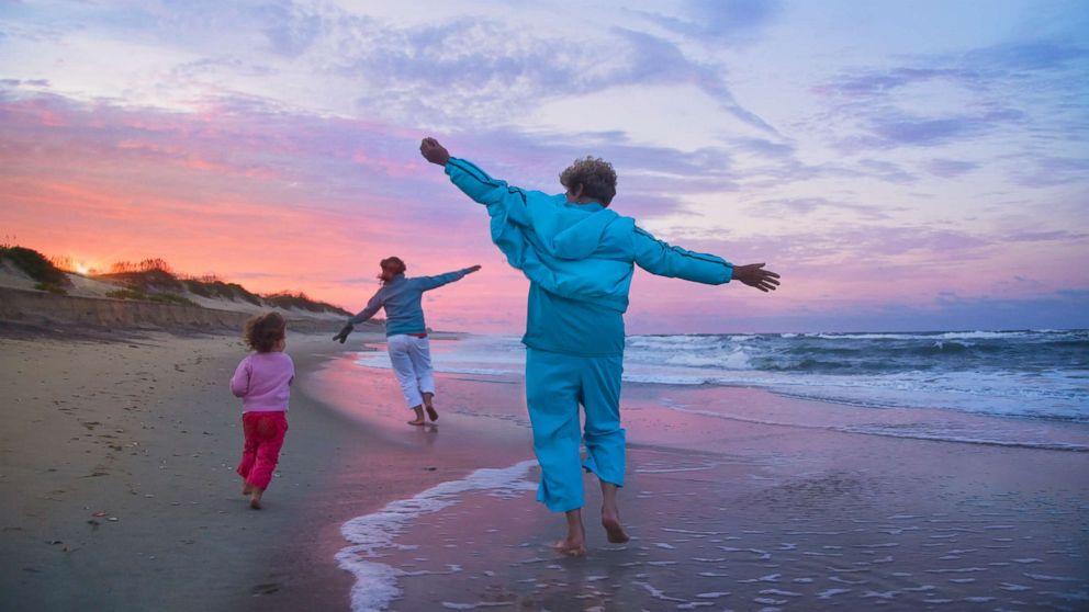 PHOTO: A mother, child, and grandmother running on a beach in an undated stock photo.