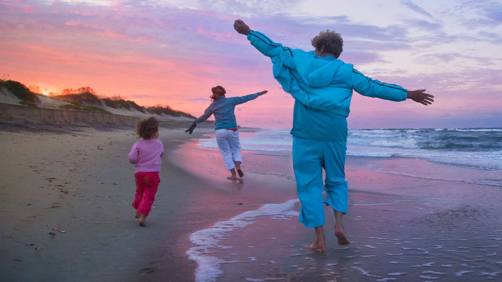 PHOTO: A mother, child, and grandmother running on a beach in an undated stock photo.