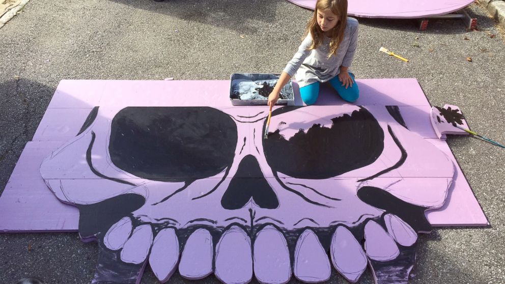 PHOTO: Michael Fry's eldest daughter Eily helping paint their giant skull decoration in 2016.