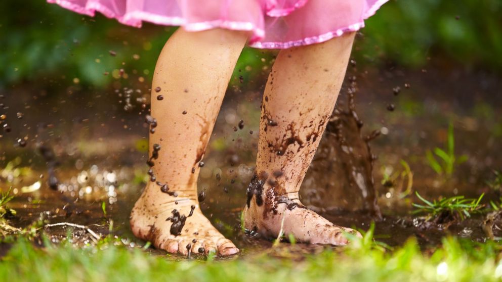 An undated stock image of a child playing in the mud. 