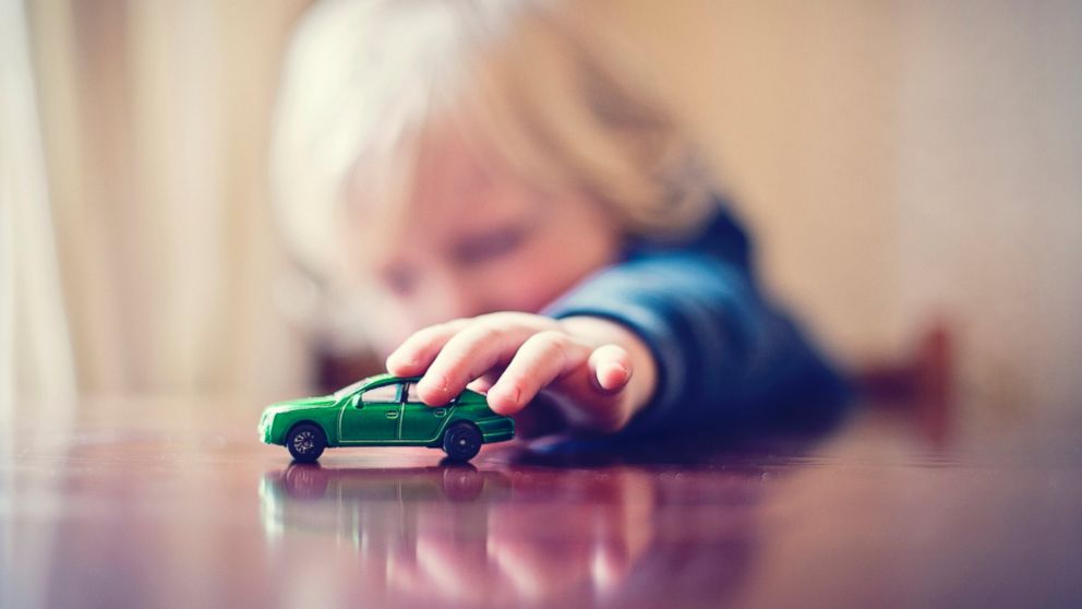 An undated stock photo shows a young boy playing with a toy car.