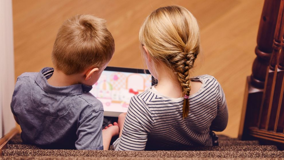 PHOTO: Two kids can be seen playing on an iPad in this stock image.