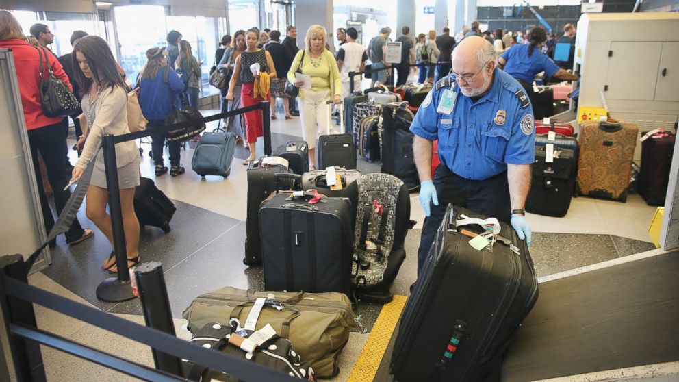 A TSA agent checks luggage as passengers arrive for flights at O'Hare International Airport on May 23, 2014 in Chicago, Ill.