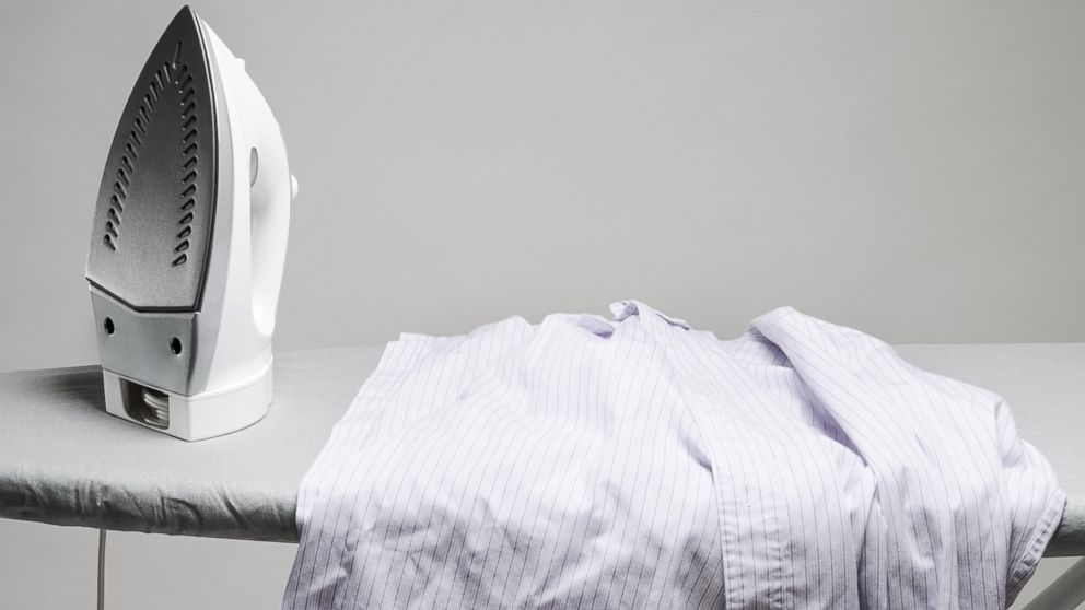 A wrinkled shirt sits next to an iron in an undated stock photo.