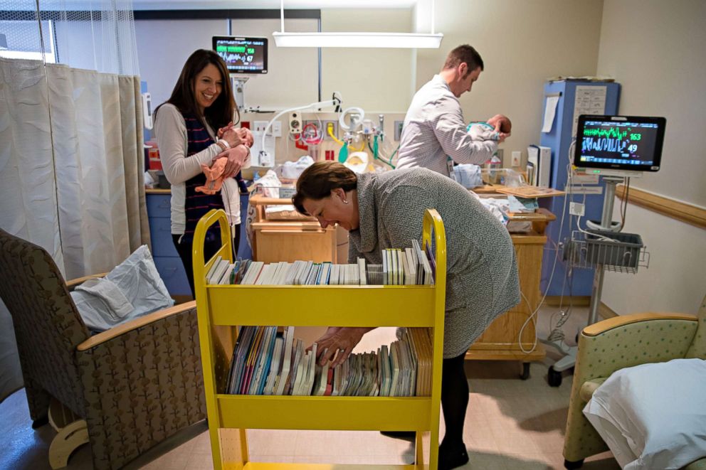 PHOTO: Suzy Guess and Brad and Kara Curran look at children's books at UPMC Magee-Womens Hospital.
