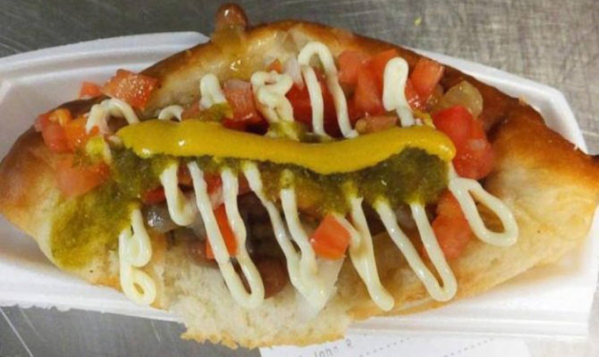PHOTO: Sonoran dogs, found primarily in Phoenix and Tucson as well as Sonora, Mexico, are bacon wrapped and topped with beans, onions, tomatoes, mayo, mustard, salsa, and crema.