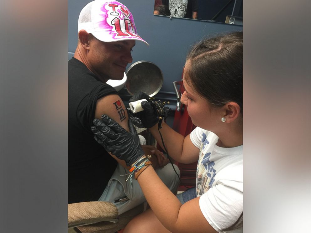PHOTO: Fraser's daughter Makayla pretends to tattoo her father.