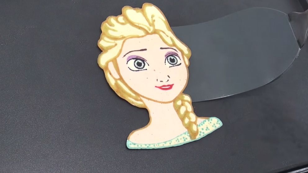 A father and son duo named "Tiger Tomato" showcases their pancake art skills on their YouTube channel. Pictured is their rendition of Elsa from "Frozen."