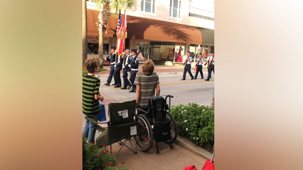 PHOTO: Arek Trenholm is wheelchair-bound but hoisted himself up to stand for the American flag. 
