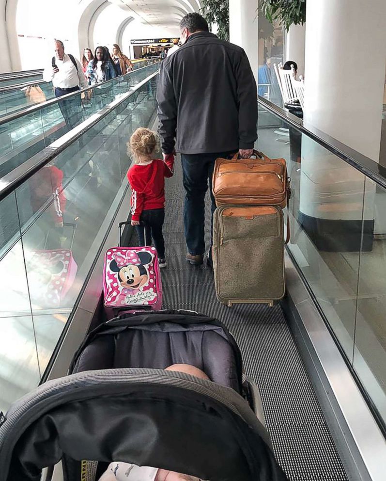 PHOTO: Todd Walker, 52, of Lenexa, Kansas, seen on April 10 walking through the airport in Charlotte, North Carolina, with Caroline Rudeen, 3.