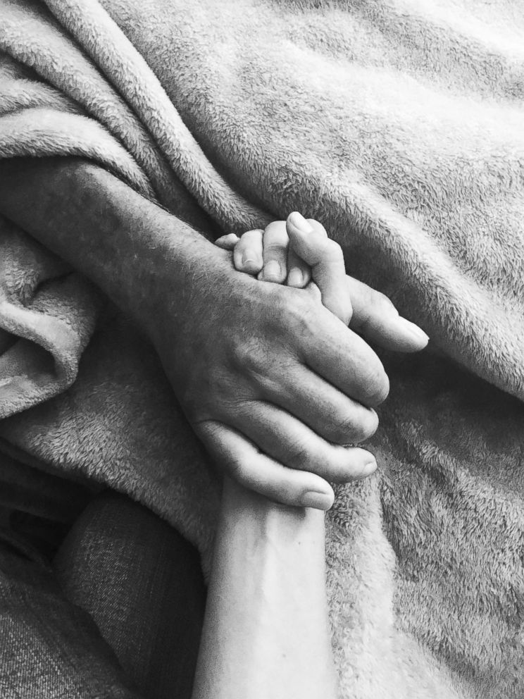 PHOTO: Kelsey Combe holds her father's hand as he died at a hospice center in New Jersey on Sep. 25, 2017.