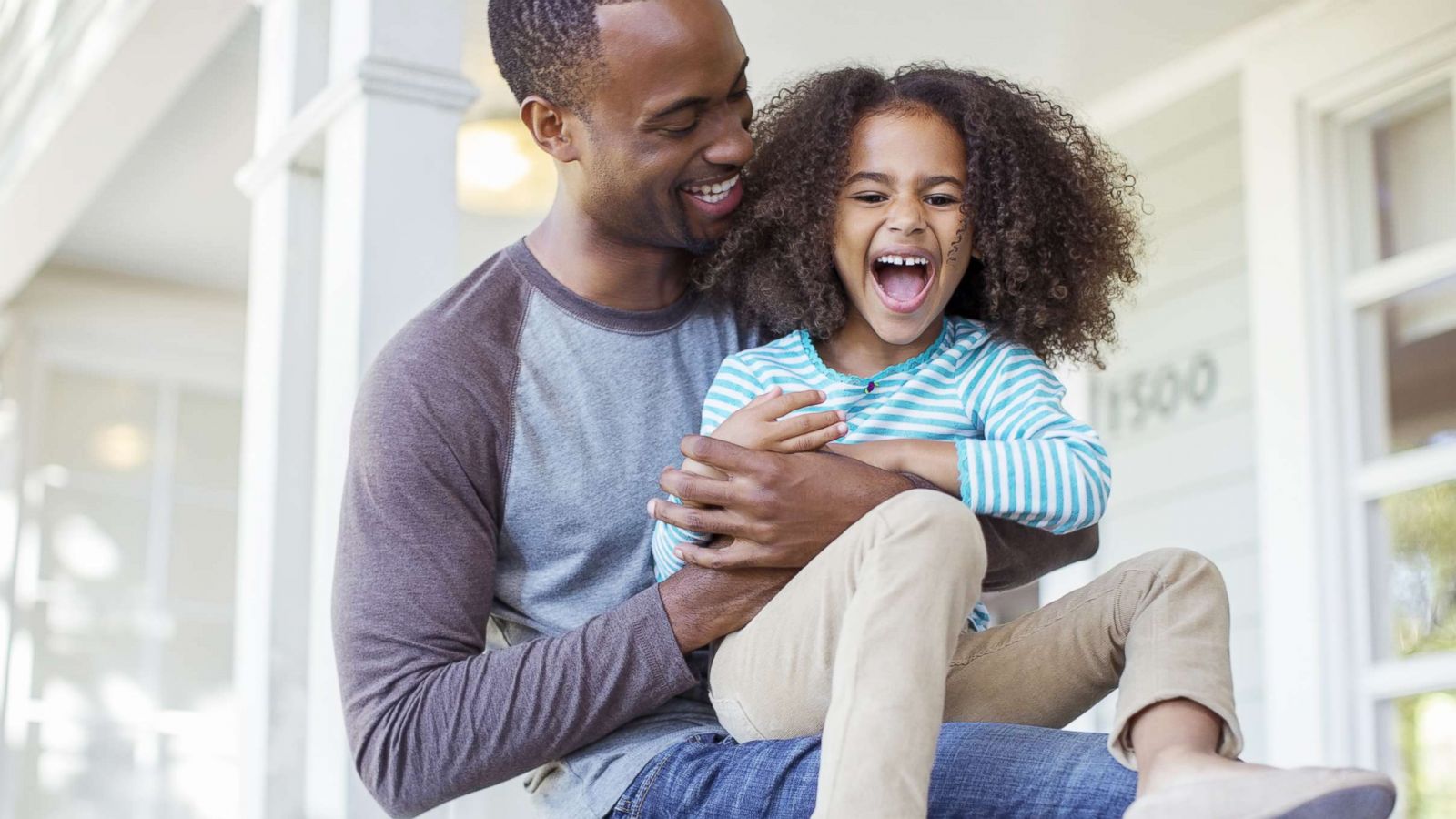 PHOTO: A father tickles his daughter on porch in this undated stock photo.