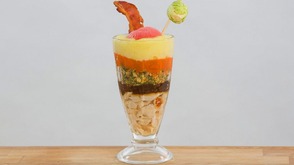 The liquid lunch is layered with turkey gel, umami-rich gravy, carrot fluid gel, dehydrated Brussels sprouts, potato infused foam, cranberry 'air' and garnished with a pancetta crisp.