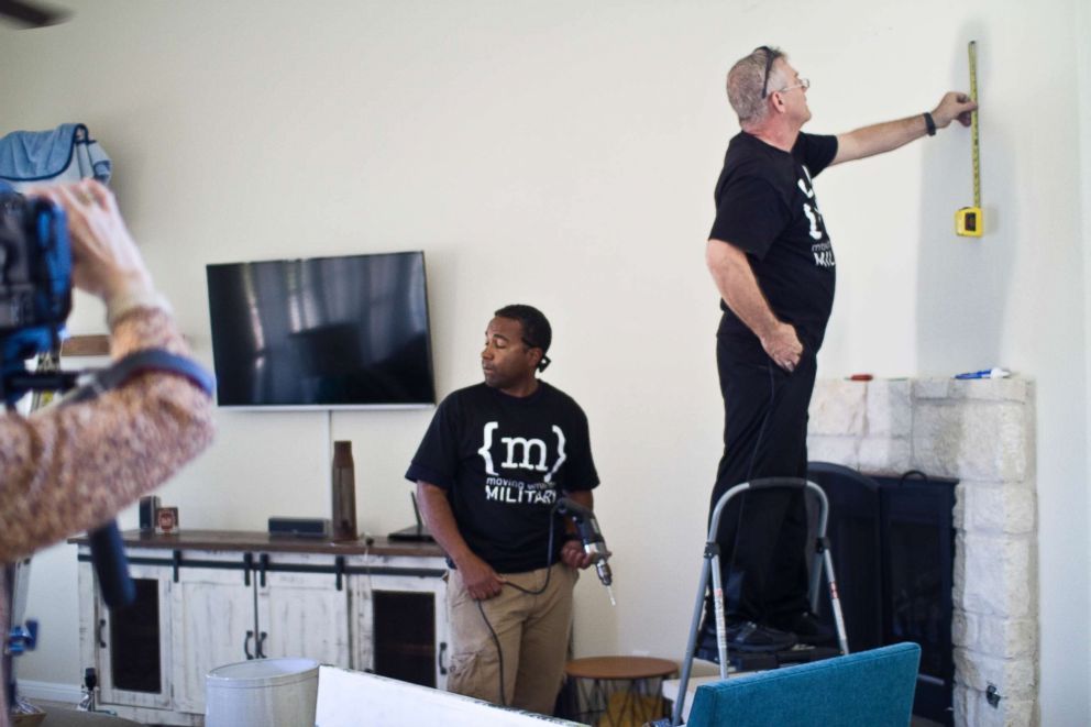 PHOTO: Volunteers help put the finishing touches on a living room transformation.