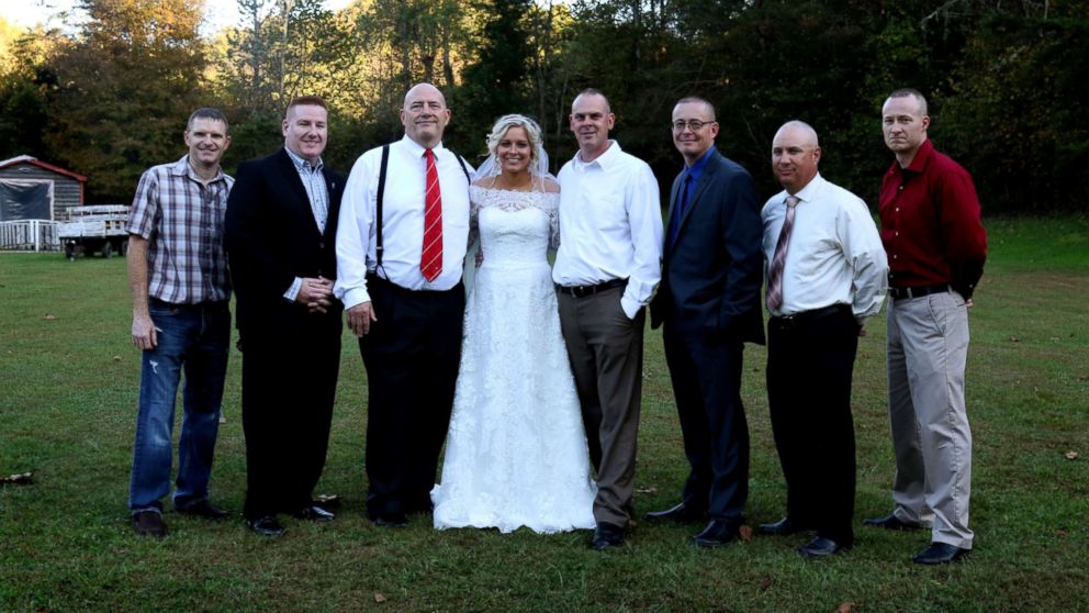 PHOTO: Mikayla Wroten poses with her father's former police colleagues after they surprised her with wedding dances.