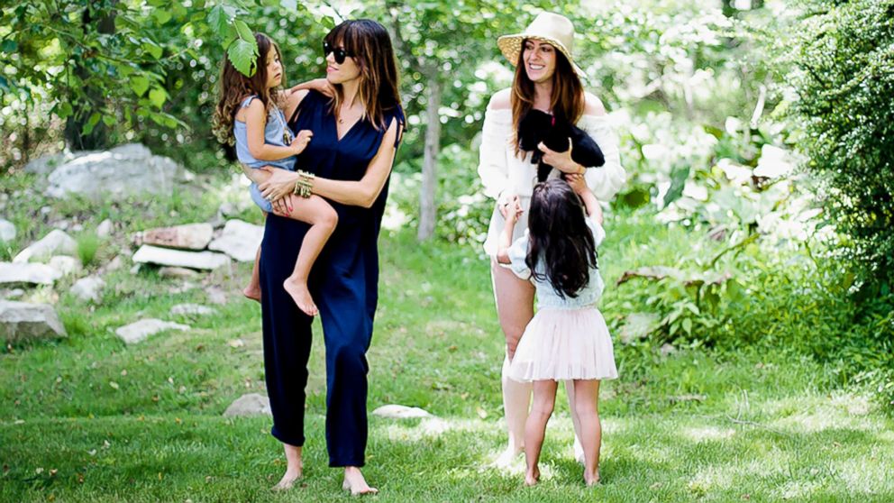PHOTO: Co-founders of the blog, Heymama.co, hold their children outdoors in this image.