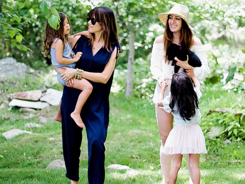 PHOTO: Co-founders of the blog, Heymama.co, hold their children outdoors in this image.