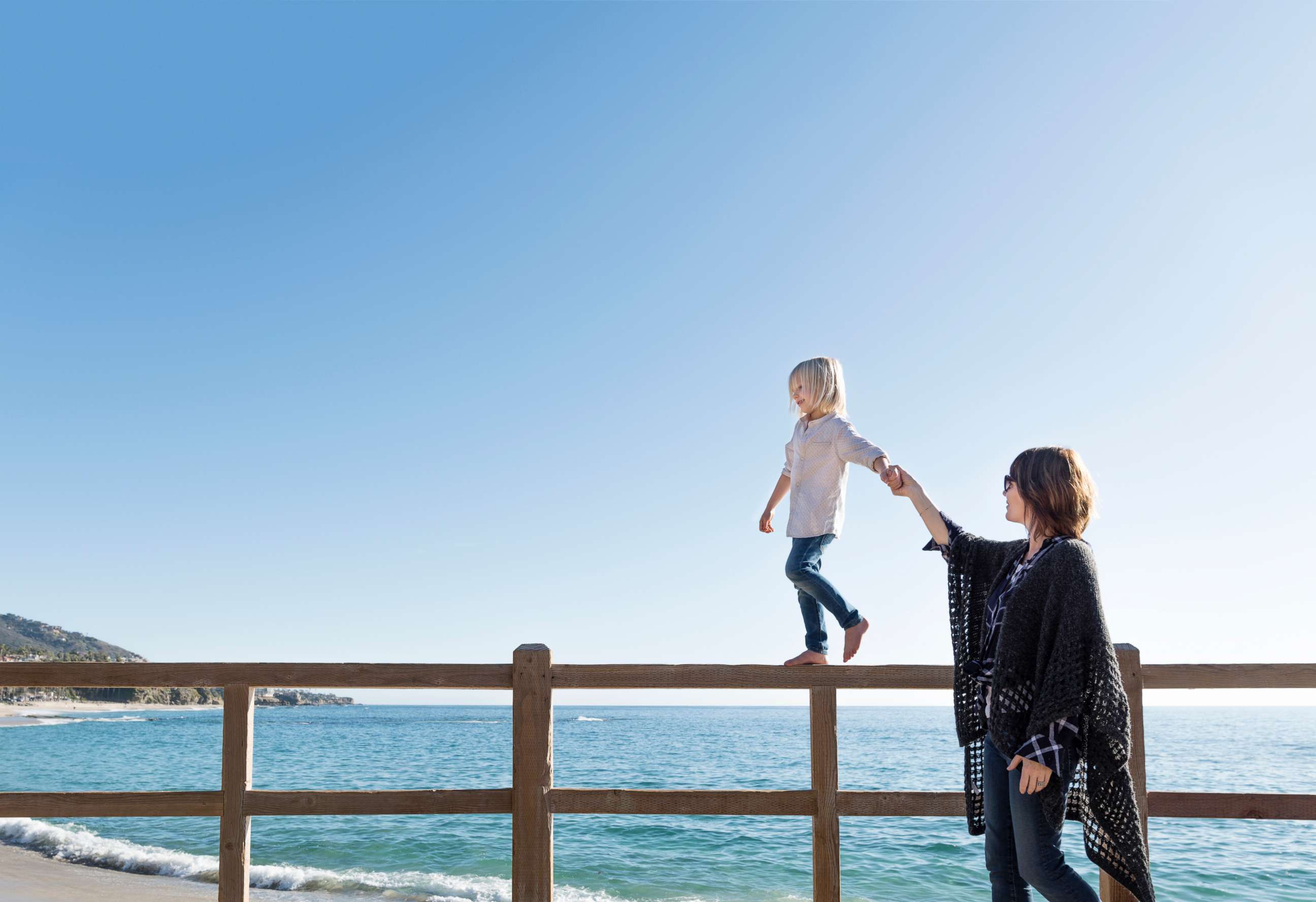 PHOTO: In this undated stock photo, a young boy walking along a fence holding his mothers hand in Laguna Beach, Calif.