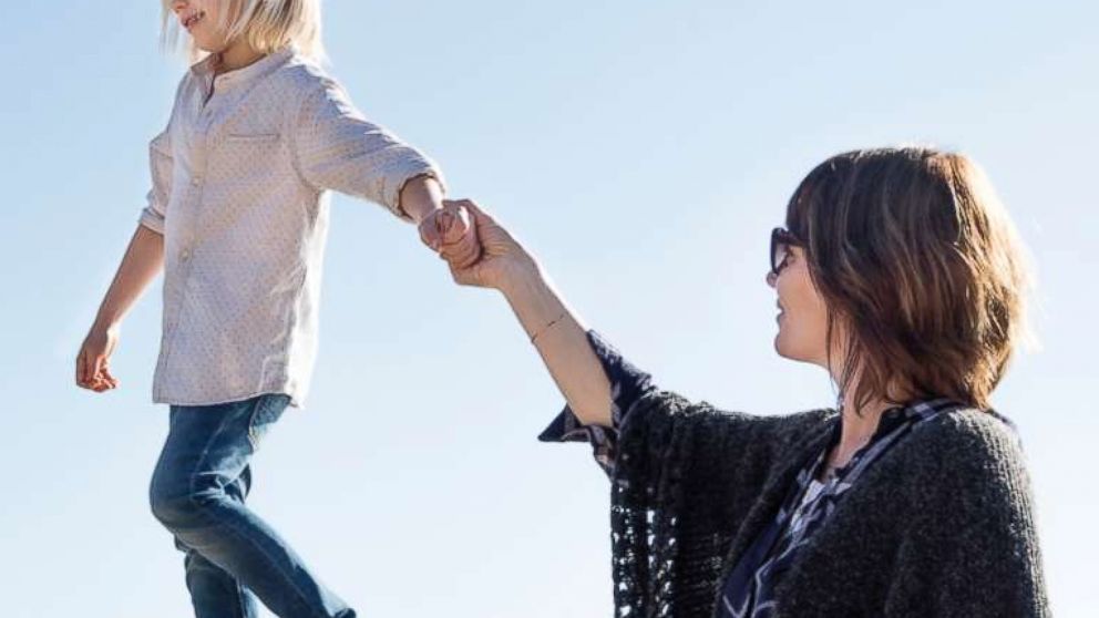 PHOTO: In this undated stock photo, a young boy walking along a fence holding his mothers hand in Laguna Beach, Calif.