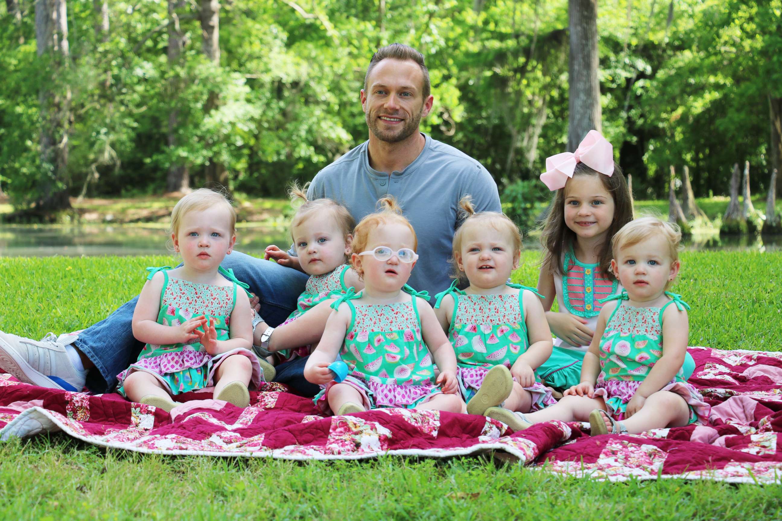 PHOTO: Adam Busby sits with his six daughters in a promotional image from the TLC show, "OutDaughtered."