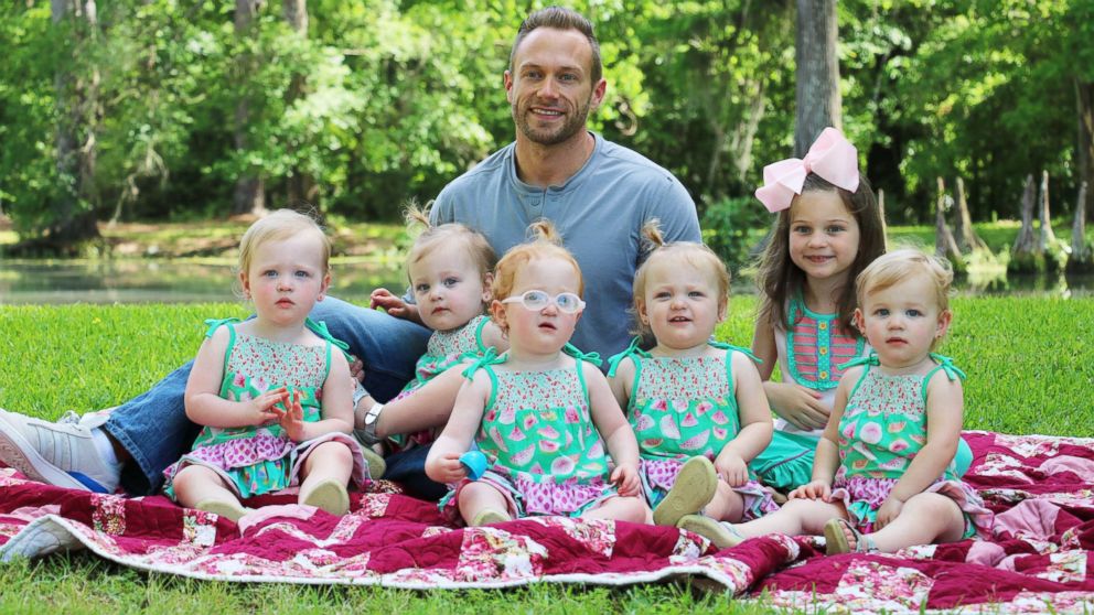 PHOTO: Adam Busby sits with his six daughters in a promotional image from the TLC show, "OutDaughtered."