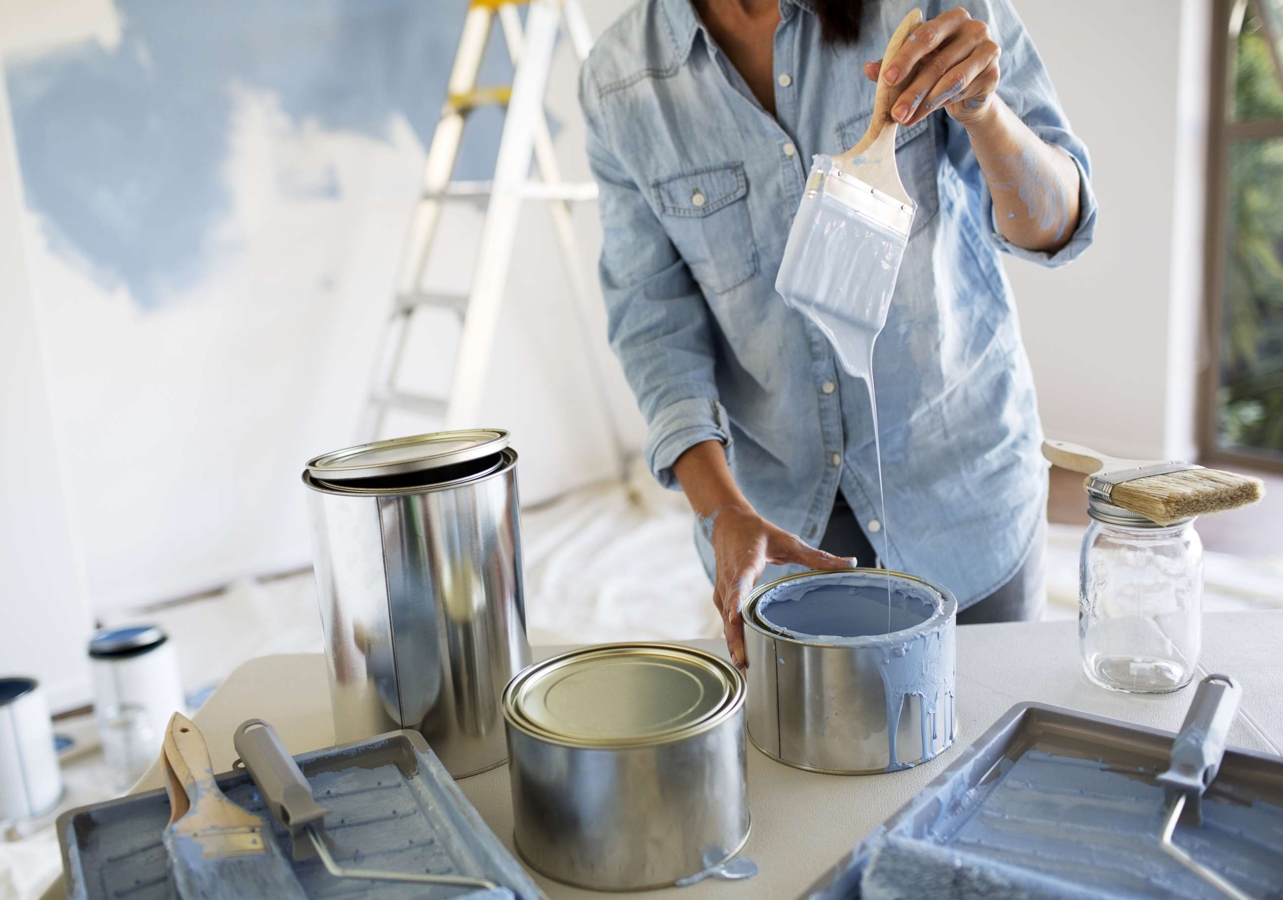 PHOTO: In this undated stock photo, a woman paints the interior of her home with blue paint.