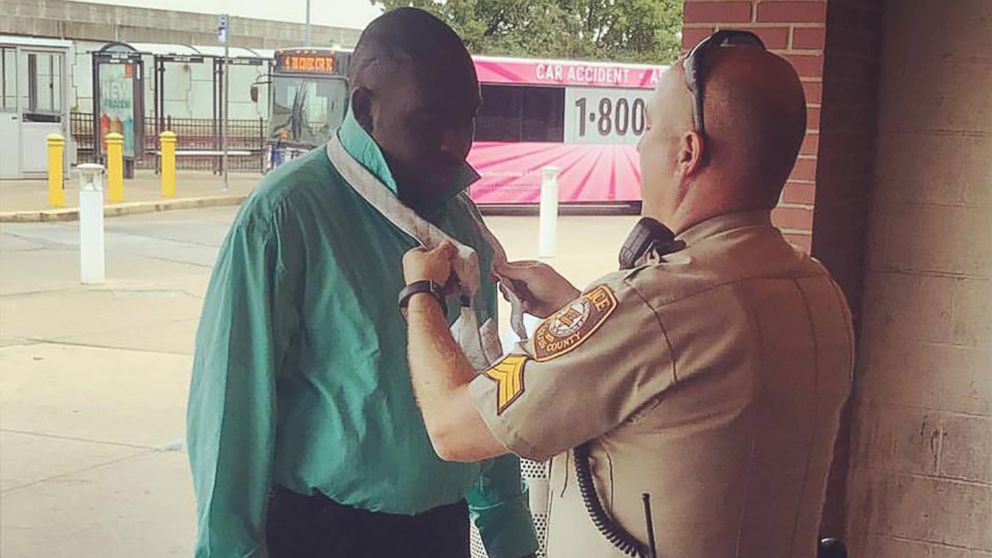 Sergeant Howard Marshall helps Willie Hatcher tie his tie before a job interview in St. Louis, Sept. 18, 2017.