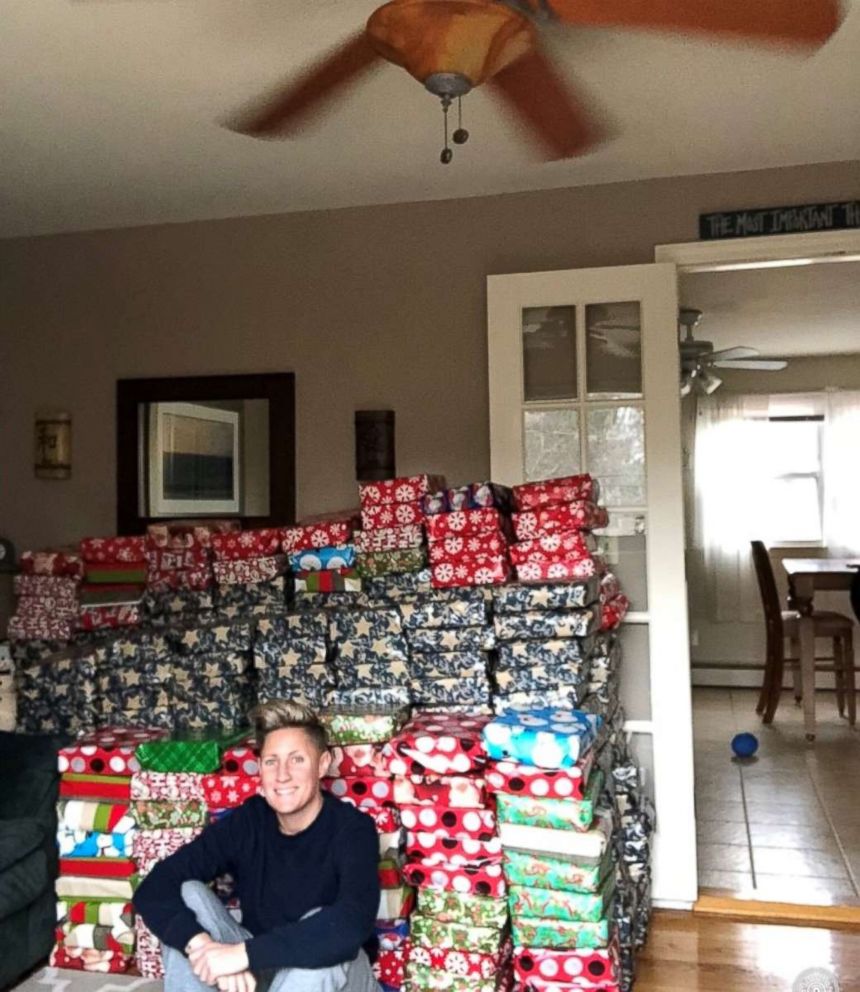 PHOTO: Jennifer Olawski poses in front of the more than 500 presents she bought for students.