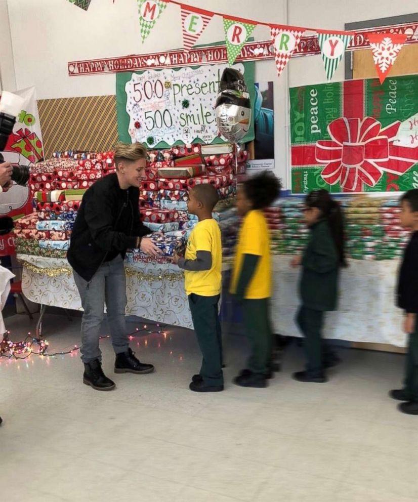 PHOTO: Jennifer Olawski presents gifts to students at Community Charter School of Paterson.