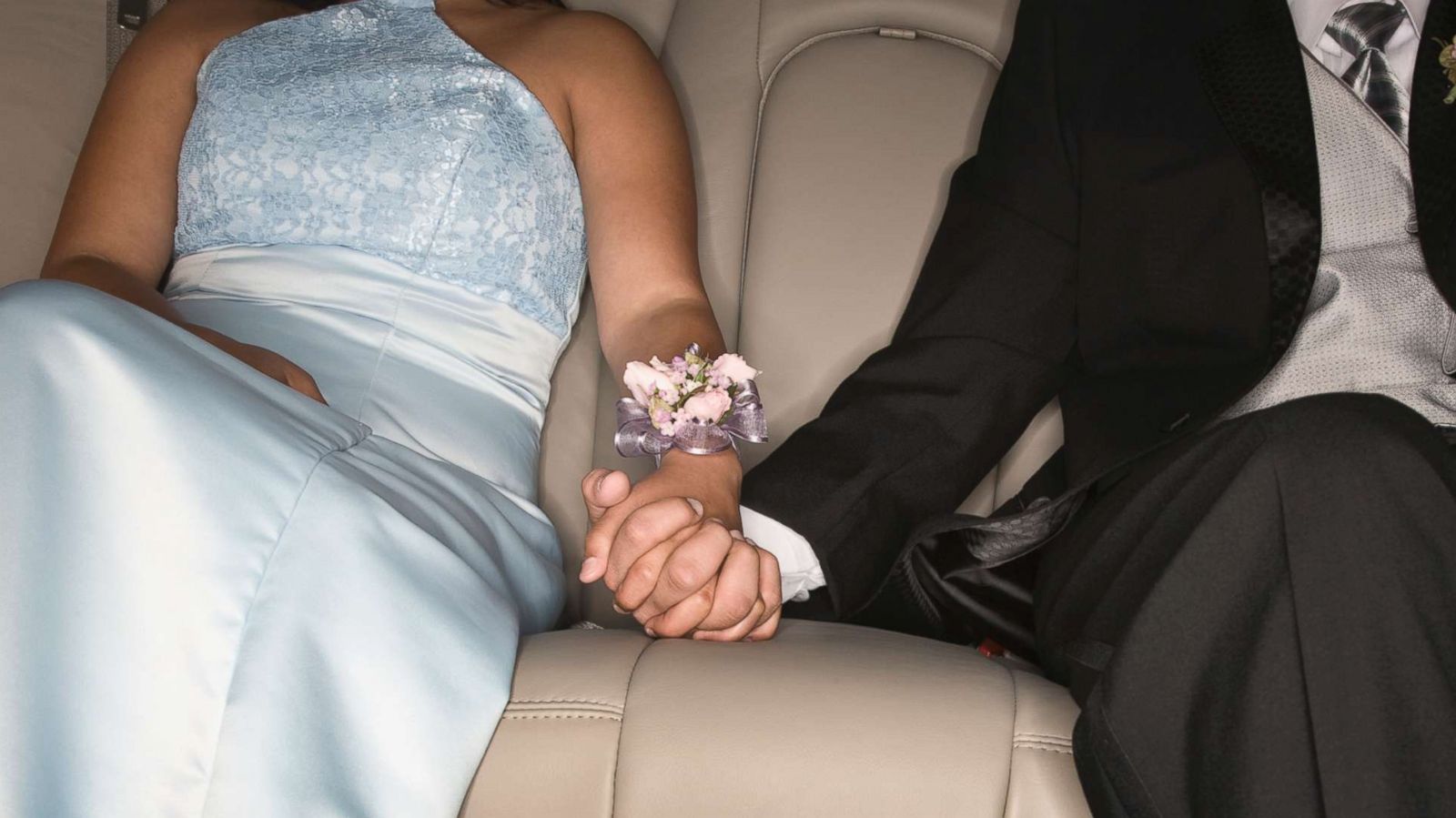 PHOTO: A young couple wearing prom outfits hold hands in the back of a limousine in an undated stock photo.