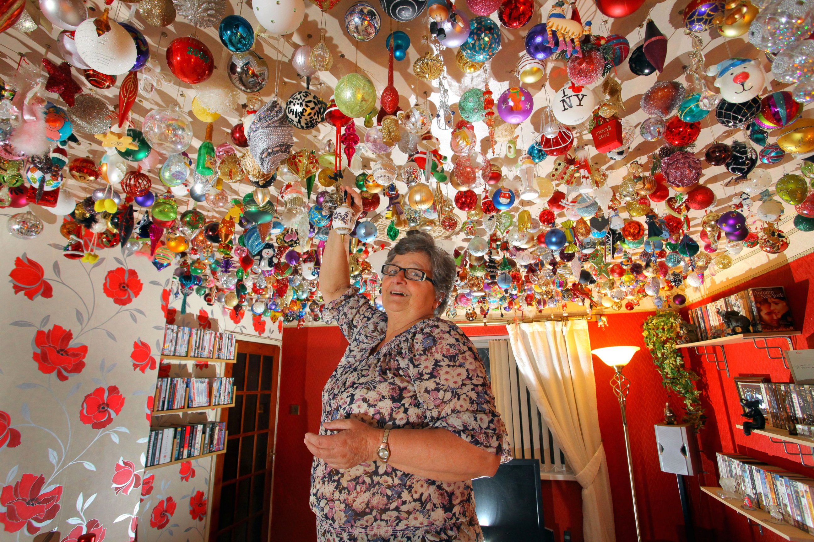 PHOTO: Sylvia Pope, of Swansea, Wales, in her living room with its ceiling covered in 1,750 Christmas ornaments, Nov. 8. 2012.