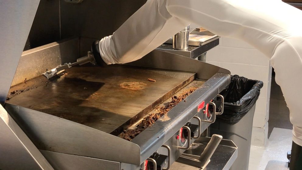 PHOTO: Flippy, the autonomous robotic kitchen assistant, cleans the grill after cooking the hamburgers.