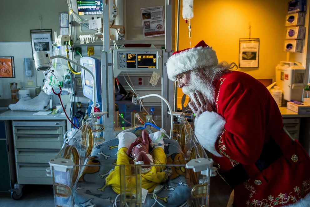 PHOTO: Santa Claus, portrayed by Dale Nowak, peers into the incubation machine to see Kayden, as he visits with 25 prematurely-born infants too small to leave the hospital, Dec. 6, 2017, at Hurley Medical Center in Flint, Mich.