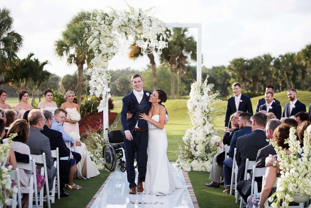 PHOTO: Chris Norton and Emily Summers-Norton standing together as newlyweds.