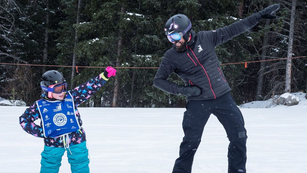 PHOTO: Lilly Biagini, 10, snowboards alongside U.S. Paralympian Keith Gabel.
