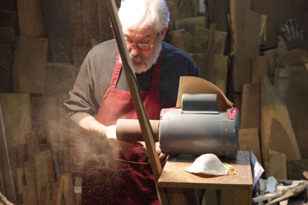 PHOTO: Woodworker Norm Sartorius sanding an abstract wooden spoon.