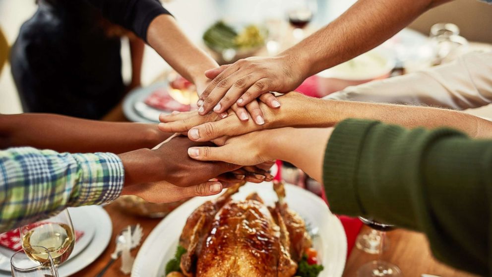 PHOTO: A family stacks their hands in celebration before a special dinner. 