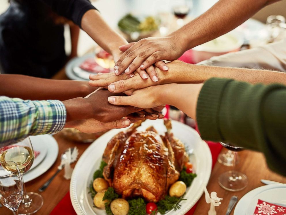 PHOTO: A family stacks their hands in celebration before a special dinner.