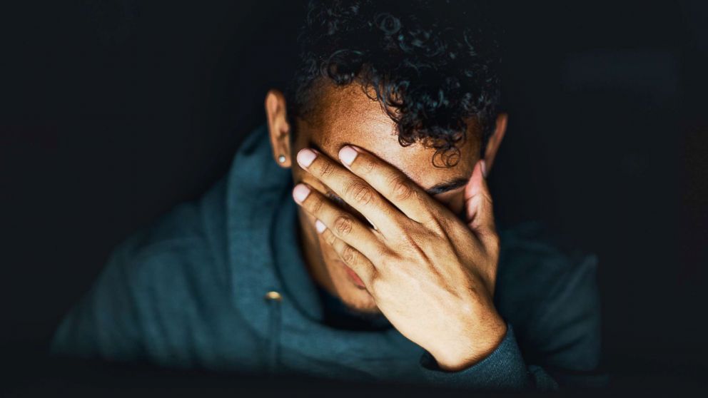 PHOTO: A young man holds his hand over his face in this undated stock image. 