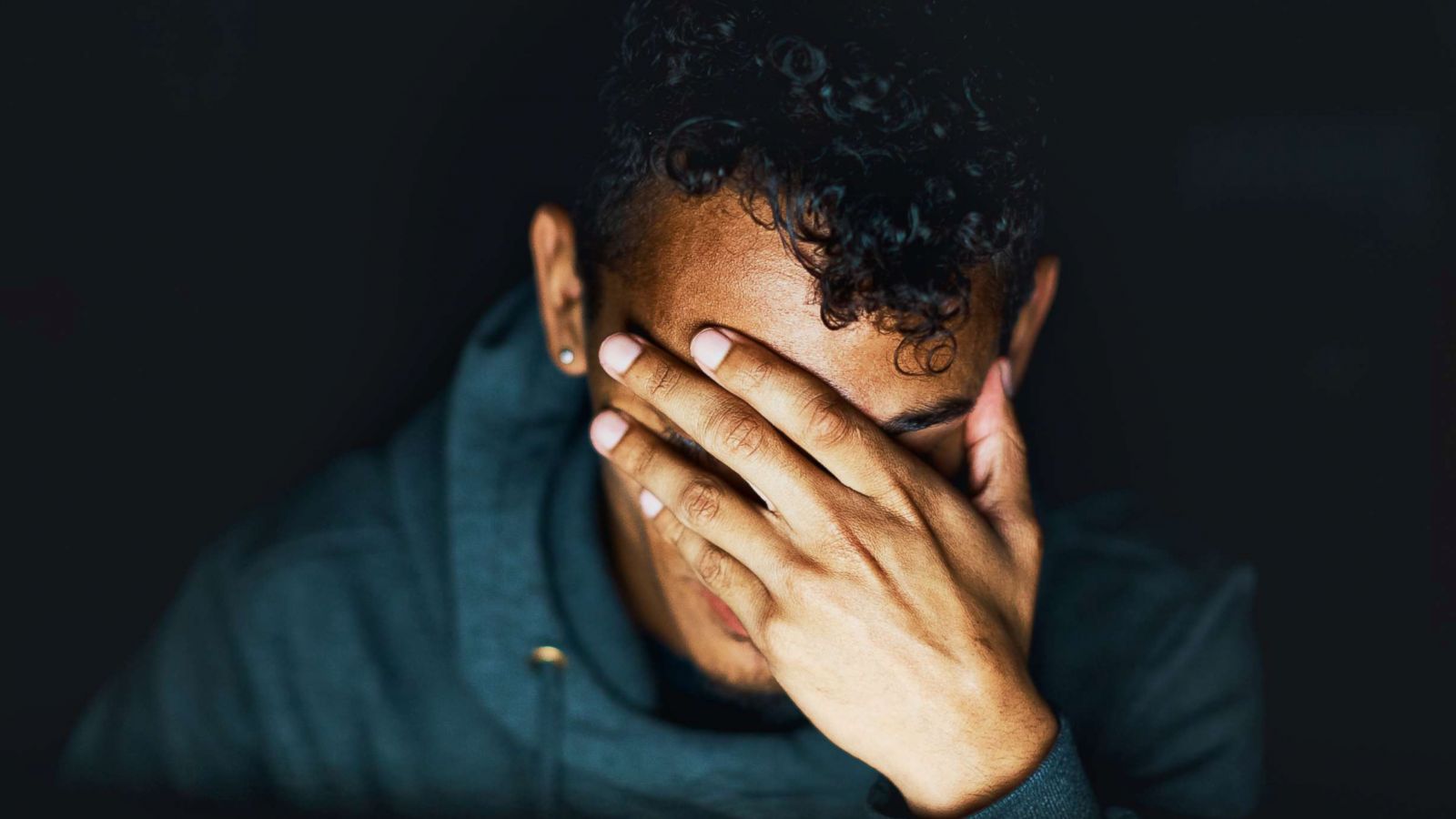 PHOTO: A young man holds his hand over his face in this undated stock image.